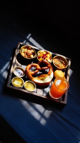 Tray of assorted German appetizers including pretzel and dipping sauces